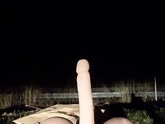 Riding a torso dildo at night in a parking lot